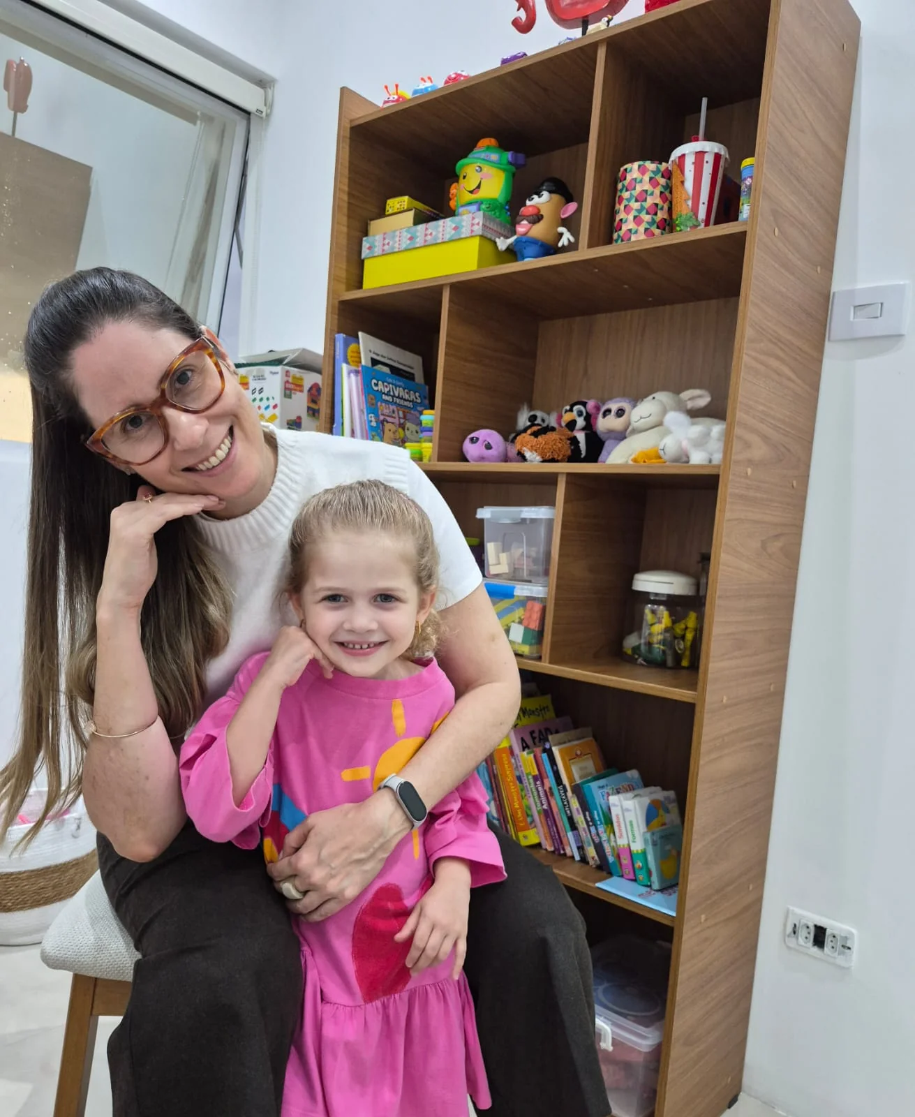 Dra. Lúcia com uma criança na sala de atendimento